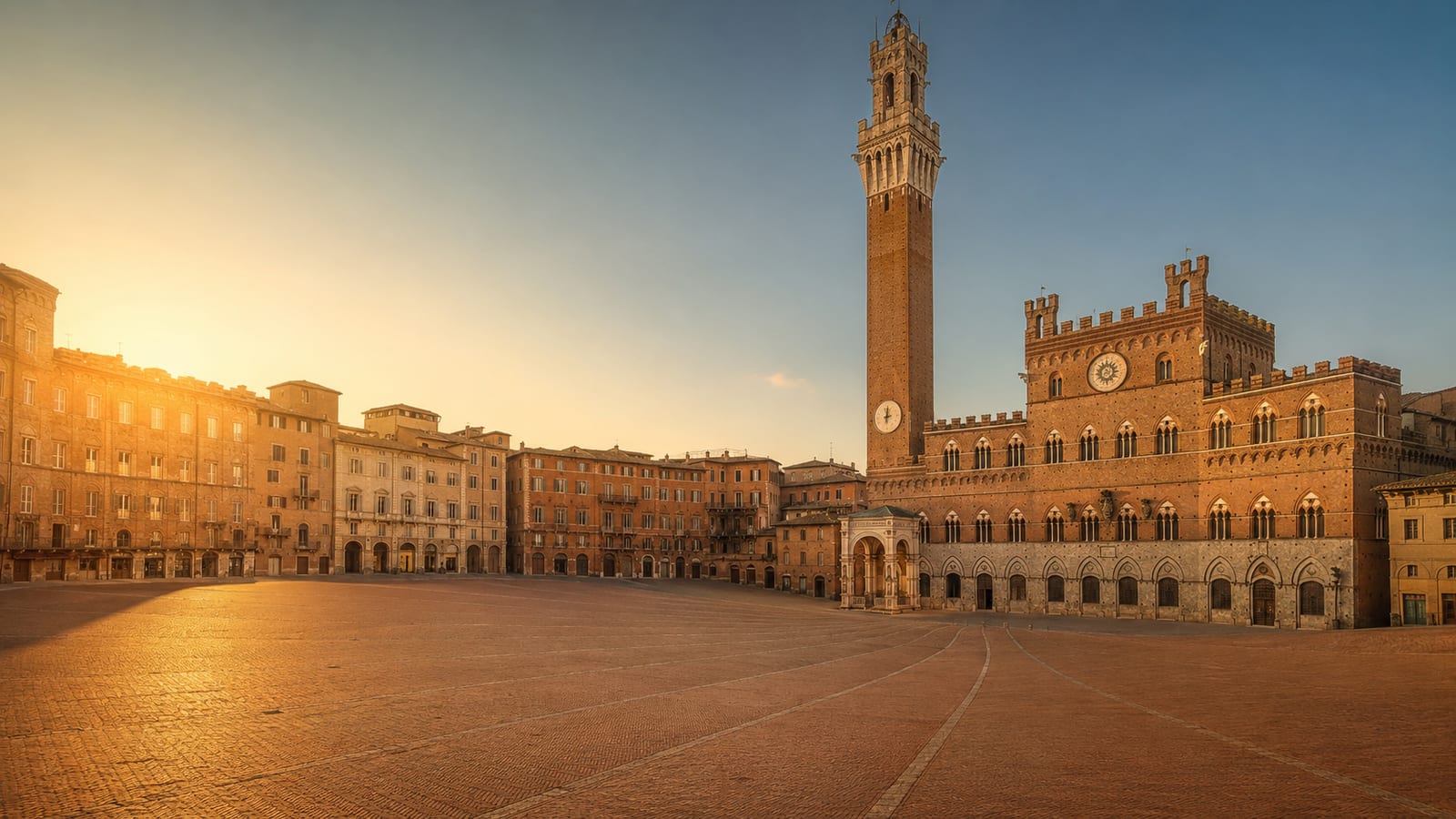 Piazza del Campo a Siena illuminata dalla luce dorata del tardo pomeriggio, la Torre del Mangia sullo sfondo