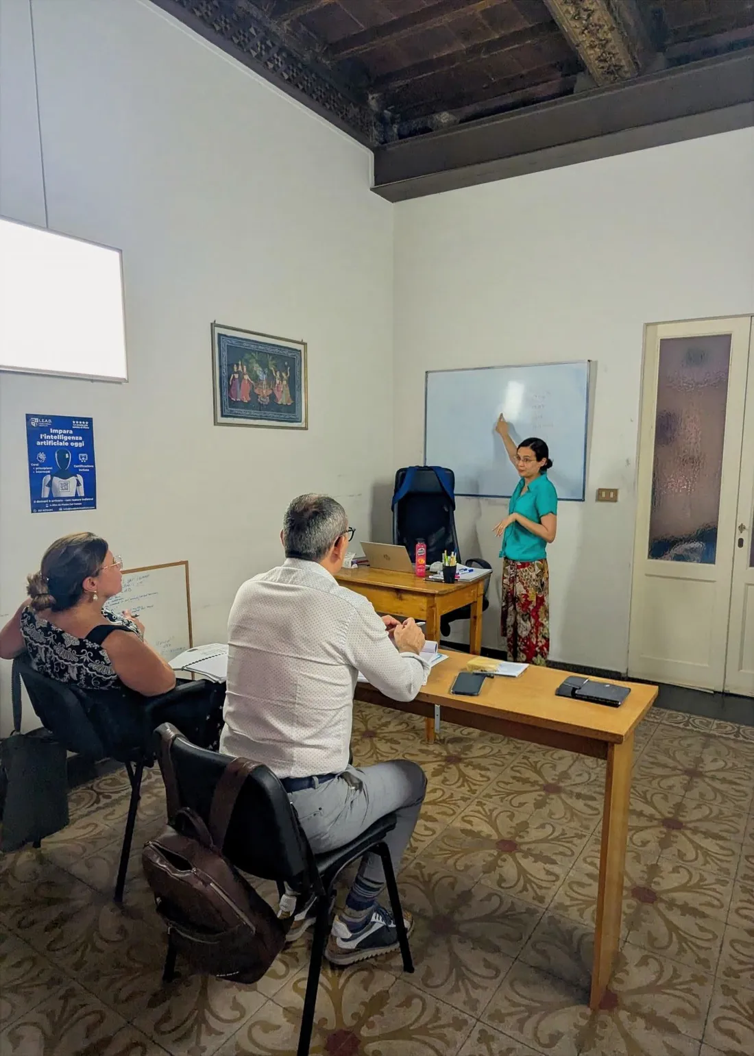 Lezione di spagnolo a LEAD Siena: la docente alla lavagna con studenti adulti.